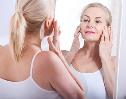 Woman looking in the mirror after BOTOX