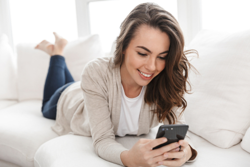 Woman looking at her cell phone with dry eyes