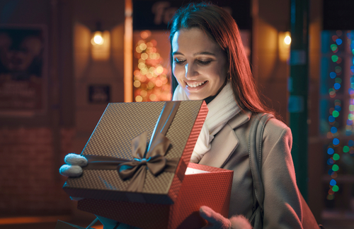 woman smiling while opening a present