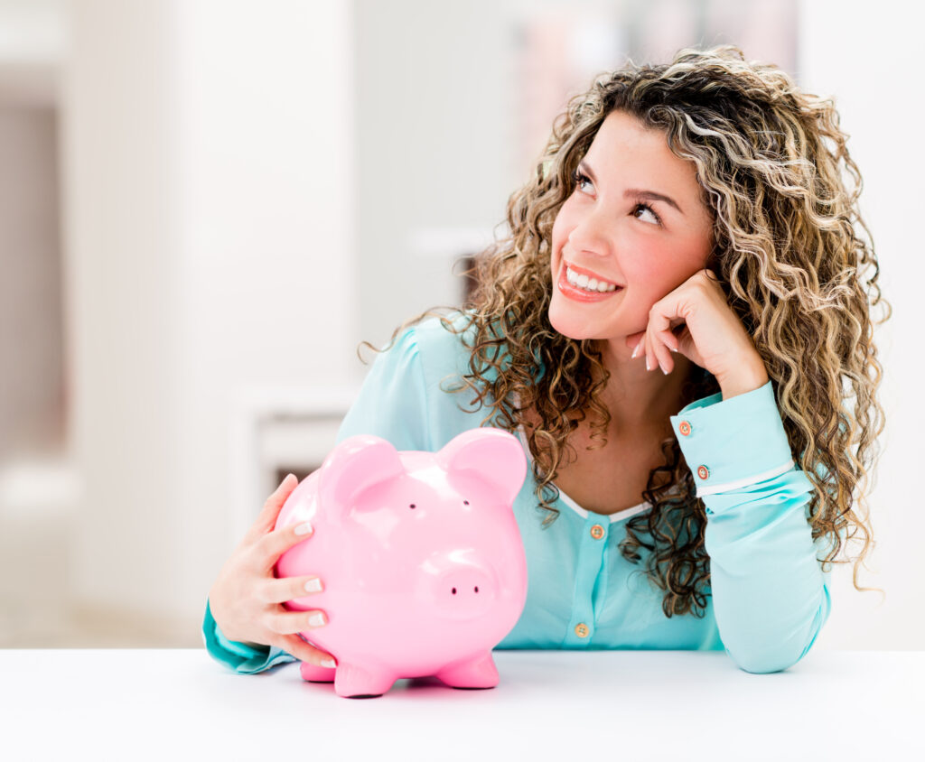 woman sitting at table with piggy bank