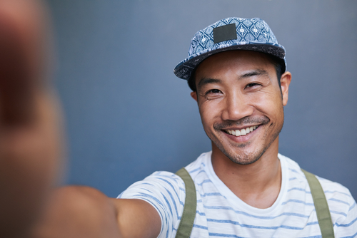 man smiling and taking selfie