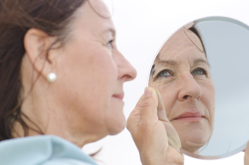 woman looking into mirror