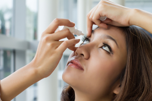 woman putting eye drops